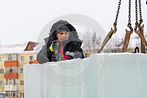 Slinger in a blue jacket unloading ice blocks photo