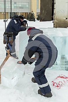 Slinger in a blue jacket unloading ice blocks photo