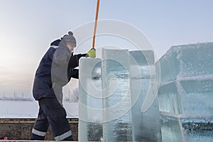 Slinger in a blue jacket unloading ice blocks photo