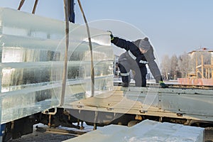 Slinger in a blue jacket unloading ice blocks photo