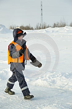 Slinger in an orange vest walks on the installation site