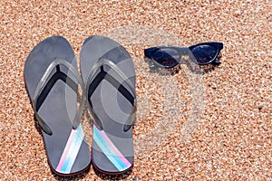 Slip slops sunscreen and sunglasses on a beach