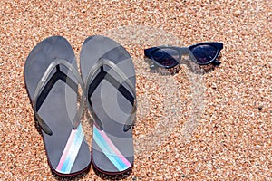 Slip slops sunscreen and sunglasses on a beach photo