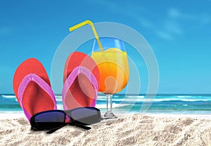 Slipper with sungalsses and drinks on a beach