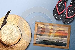 Slippers and a beach hat for traveling with a small chalkboard with a view of the sunset scene on the beach