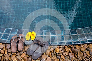 Slippers on edge of swimming pool