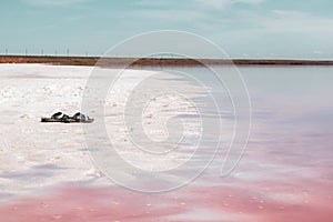 Slippers left on pink salt lake coast, Syvash sea