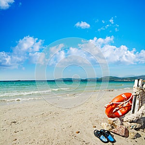 Slippers and life buoy by the shore in Alghero