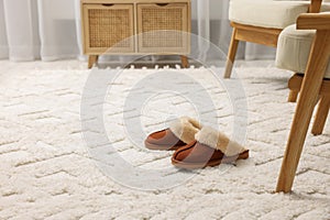 Slippers on soft white carpet in living room