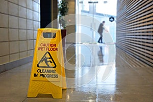 Slippery floor surface warning sign and symbol on a wet floor photo