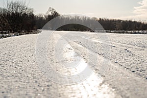 Slippery frozen road on gloomy winter day, close up