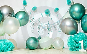 sliver, blue and white decoration for a 1st birthday cake smash studio photo shoot with balloons, paper decor, cake and