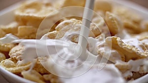 Slo-mo milk poured onto cereal corn flakes