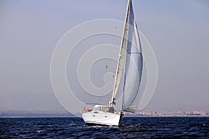 Sloop sailboat on a quiet sea in open waters.