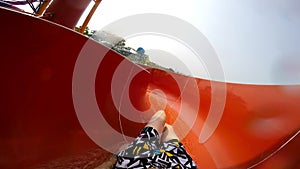 Slope down by water slide in water park. Fun travel inside of the multi color tube at aqua park filmed on action camera.