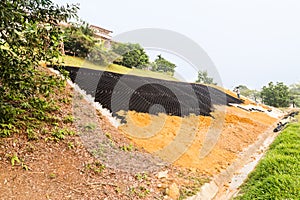 Slope erosion control with grids and earth on steep slope photo