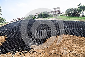 Slope erosion control with grids and earth on steep slope.