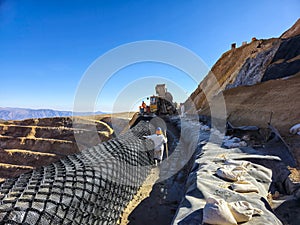 Slope stabilization with shotcrete and geosynthetic materials