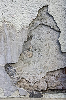 Sloping plaster with cracks in several layers on house wall reno