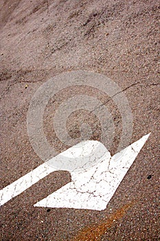 Sloping White Painted Arrow On Asphalt Road Surface
