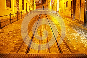 Slopped cobblestone street with tram tracks in the old town, evening scene, Lisbon, Portugal