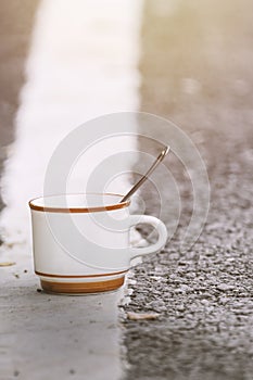 A sloppy coffee cup is placed on the street