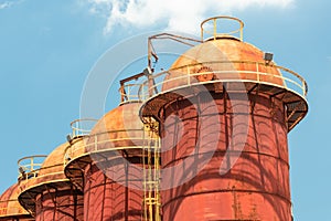 Sloss Furnaces National Historic Landmark, Birmingham Alabama USA, row of bright orange rusted blast furnaces against a blue sky