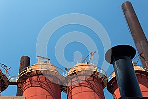 Sloss Furnaces National Historic Landmark, Birmingham Alabama USA, trio of blast furnaces, rusted with smokestacks against a blue