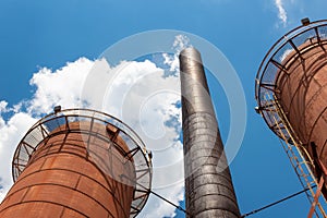 Sloss Furnaces National Historic Landmark, Birmingham Alabama USA, two furnaces and smokestack reach skyward against a brilliant b