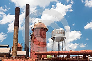 Sloss Furnaces National Historic Landmark, Birmingham Alabama USA, water tower, furnaces and smoke stacks, blue sky with clouds