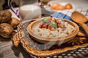 Slovak traditional dishes potato gnocchi with sheep`s cheese, on a wooden table laid on the table