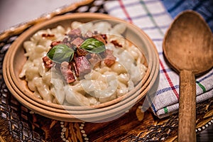 Slovak traditional dishes potato gnocchi with sheep`s cheese, on a wooden table laid on the table