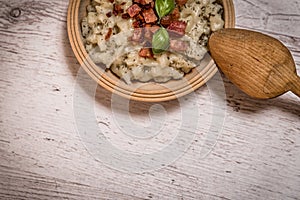Slovak traditional dishes potato gnocchi with sheep`s cheese, on a wooden table laid on the table