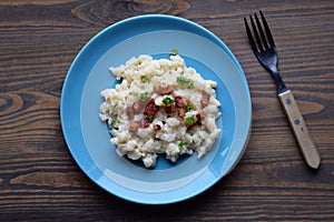 Slovak traditional potato gnocchi with sheep cheese and bacon,wooden table