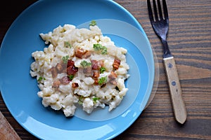 Slovak traditional potato gnocchi with sheep cheese and bacon,wooden table