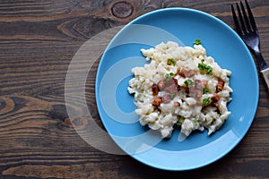 Slovak traditional potato gnocchi with sheep cheese and bacon,wooden table