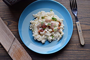 Slovak traditional potato gnocchi with sheep cheese and bacon,wooden table