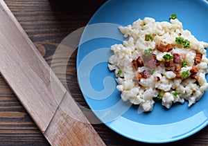 Slovak traditional potato gnocchi with sheep cheese and bacon,wooden table