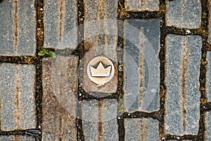 Slovakia, Bratislava. Brass crown marker in cobblestone streets show location of the coronation walk. Old town. Top view