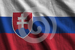 Slovakia flag with big folds waving close up under the studio light indoors. The official symbols and colors in banner