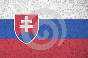Slovenská vlajka zobrazená jasnými farbami na starej reliéfnej omietke. Textúrovaný banner na hrubom pozadí