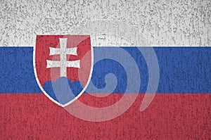 Slovenská vlajka zobrazená v jasných barvách na staré reliéfní omítce. Texturovaný banner na hrubém pozadí