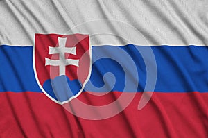 Slovakia flag is depicted on a sports cloth fabric with many folds. Sport team banner