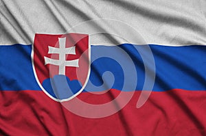 Slovakia flag is depicted on a sports cloth fabric with many folds. Sport team banner