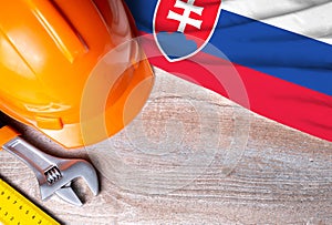 Slovakia flag with different construction tools on wood background, with copy space for text