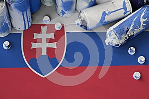 Slovakia flag and few used aerosol spray cans for graffiti painting. Street art culture concept