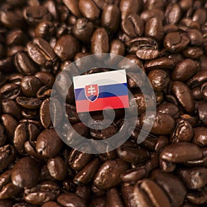 Slovenská vlajka umístěná nad praženými kávovými zrny