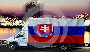 Slovakia flag on the side of a white van against the backdrop of a blurred city and river. Logistics concept