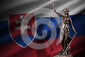 Slovakia flag with statue of lady justice and judicial scales in dark room. Concept of judgement and punishment