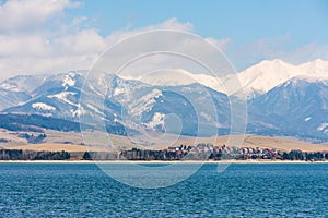 Slovakia: Small village near the Tatra mountain. Liptovska Mara lake in foreground. Winter and snow mountain.